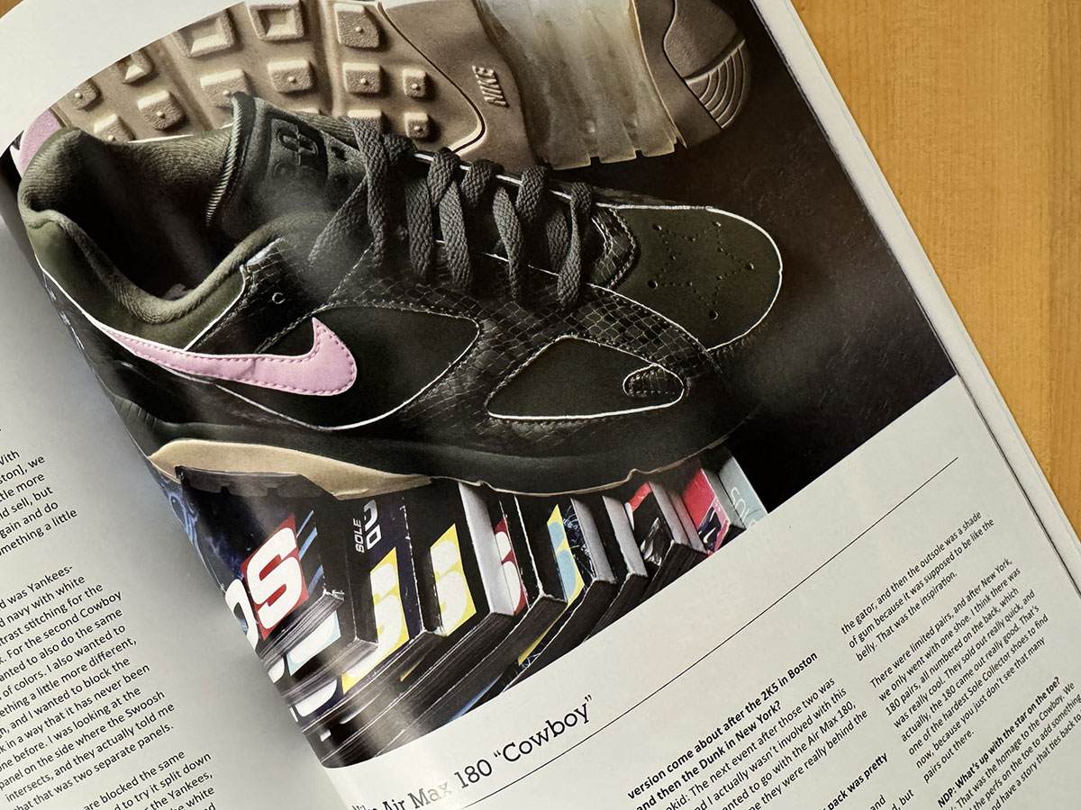 The Sole Collector x Nike Air Max 180 Cowboy in black snakeskin with a pink Swoosh, photographed above a fanned row of Sole Collector back issues.