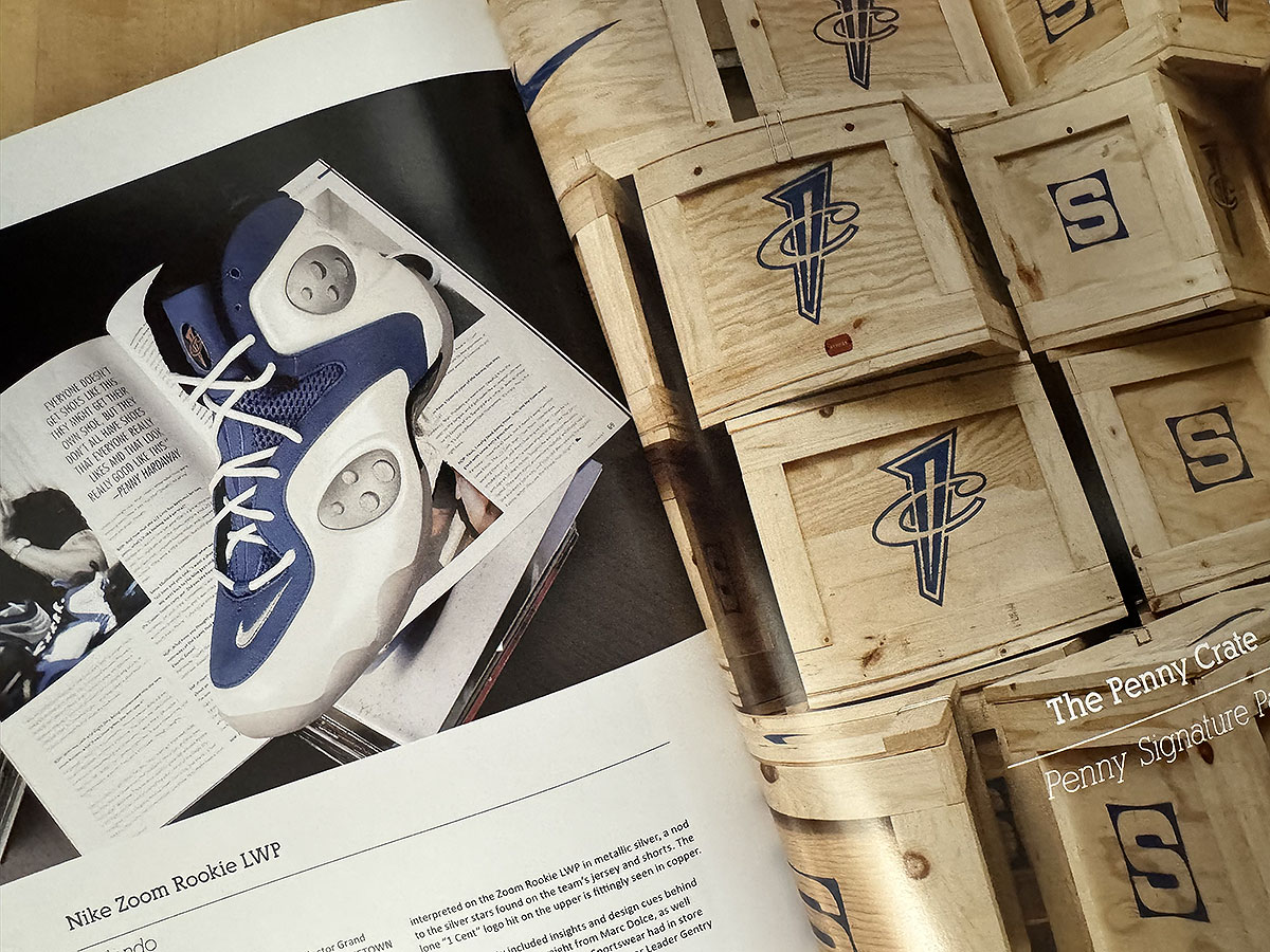 The Nike Zoom Rookie LWP in blue and white on the left page, beside a stack of wooden Penny Crate shipping boxes stamped with the 1Cent logo and the Sole Collector S.
